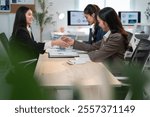 Two businesswomen shaking hands in a modern office, showing teamwork and partnership. Bright workspace exudes confidence and happiness, with focus on professional success and collaboration