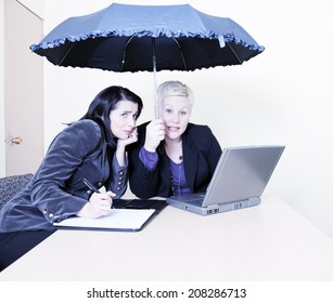 Two Businesswomen Under An Umbrella Indoors