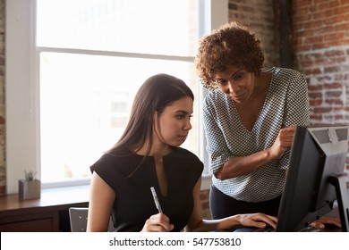 Two Businesswomen Working On Computer In Office