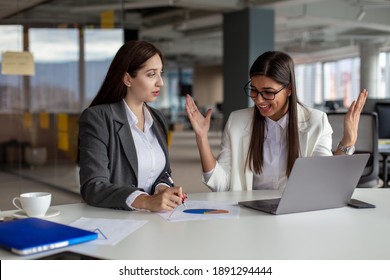 Two businesswomen are working on laptops in the office. - Shutterstock ID 1891294444