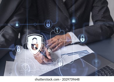 Two businesswomen working on the project to protect cyber security of international company. Padlock Hologram icons over the table with documents. - Shutterstock ID 2029739648