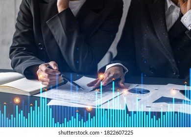 Two businesswomen working together in office. Financial graph holographic illustration double exposure. - Powered by Shutterstock