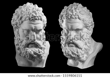 Two bust of Hercules. Heracles head sculpture, plaster copy of a statue isolated on black. Son of Zeus. Ancient statue of hero.