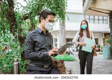 Two Busy Worker Sitting In The Park During Office Break Using Phone