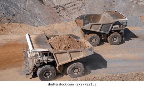 Two CAEX teams crossing paths on a mining road transporting minerals from the bottom of a mine pit