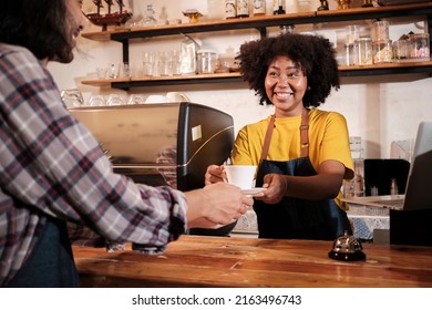 Two cafe business startup partners and friends, African American female, and Thai male baristas work and cheerful smile together at counter bar of coffee shop, happy service job, and SME entrepreneur. - Powered by Shutterstock