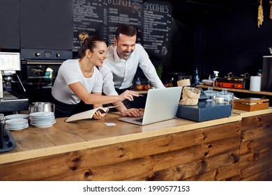 Zwei Kaffeehäuser planen gemeinsam Lieferaufträge auf Laptop