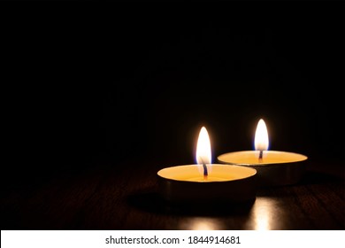 Two Candles Burning In The Black Background. The Concept Of Mourn, Grief Or Mourning.