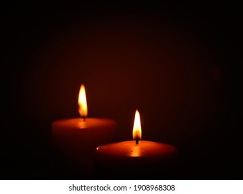 two candles burning in dark
