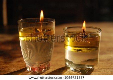 two candles burning in a glass