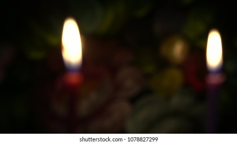 Two Candles Are Burning On Flower Colorful Background. The First Day Of The Jewish Holiday Of Hanukkah. Blurred View,