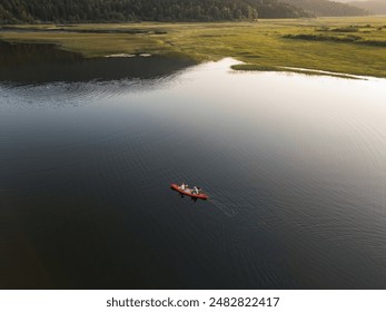 Two canoeists enjoying summer holiday activity, paddling a canoe in the tranquil lake at sunset, aerial shot. Travel and active lifestyles concept. - Powered by Shutterstock