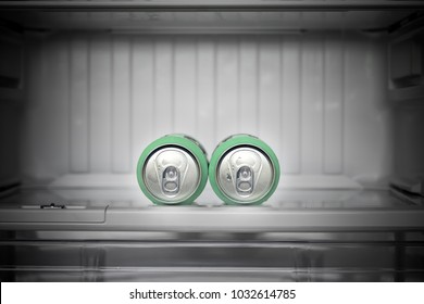 Two Cans Of Beer Lie In An Empty Fridge. Dewy Cans With Beer On A Shelf In The Refrigerator.