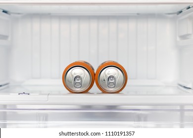 Two Cans Of Beer Lie In An Empty Fridge. Dewy Cans With Beer On A Shelf In The Refrigerator.