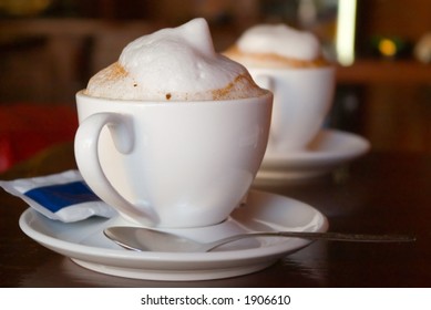 Two cappuccino cups with milk foam and cinnamon - Powered by Shutterstock