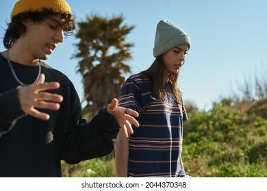 Two Captivated Young People In Deep Conversation While Standing On A Hill