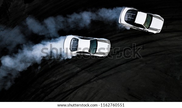 Two car drifting battle on asphalt street rad race\
track, Race car drift performance view from above, Car drifting,\
Automobile and automotive drift car with smoke from burning tire on\
speed track.