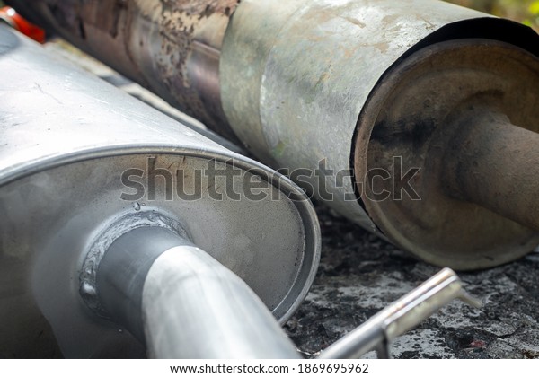 Two car exhaust pipes with a\
silencer. Replacing the old exhaust pipe with a new one, improving\
the environmental friendliness of the car. Selective\
focus