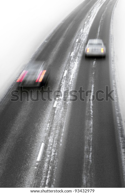 Two cars in\
blurred motion on winter\
highway