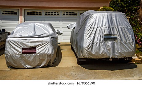 Two Cars Covered In Silver Car Covers In Suburban Driveway. Could Be Used For Coronavirus Humor