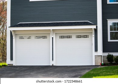 Two Cars Garage Door Painted In Black Color In A Typical Single House