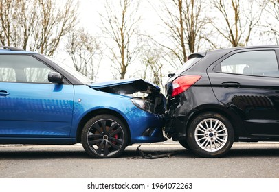 Two cars involved in traffic accident on side of the road with damage to bonnet and fender - Shutterstock ID 1964072263