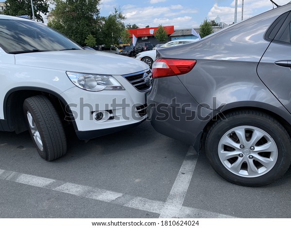 Two cars next to each other.\
Cars are parked very close. Small clearance from bumper to bumper.\
Irpen, Kiev region, supermarket parking, August 23,\
2020.