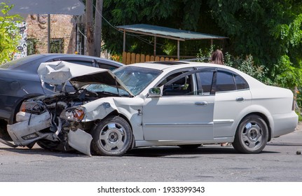 two cars on the road after the collision. Damaged white car on the road after the accident