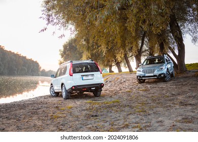 Two Cars Parked At Autumn River Beach. Copy Space