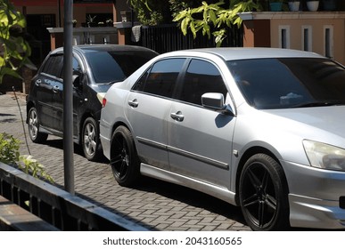 Two Cars Parked On The Street.