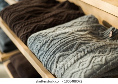 Two cashmere cardigans in gray and brown. Woolen cardigans on the shelf. Cashmere cardigans in men's wardrobe