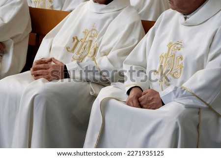 Two Catholic priests sitting on a church pew during Sunday mass