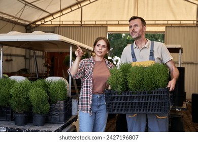 Two caucasian botanists working in greenhouse over plants seedling - Powered by Shutterstock