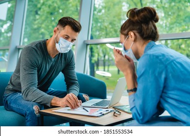 Two Caucasian Business Partners Wearing Medical Masks Against Covid19 Signing Contract In Office