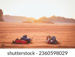 Two caucasian lovers couple watch sunset together tired in wadi rum desert on holiday vacation abroad share memories experiences travel together while young on sunset over horizon