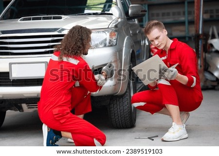 Two caucasian man hispanic Accident Inspector Inspect damage car caused by car crash on the road. Car insurance agent examining by Claim form clipboard and laptop computer in garage. Motor insurance