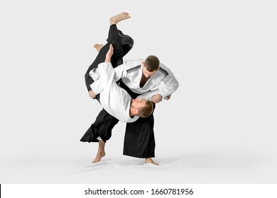 Two caucasian men are practicing aikido on the tatami (isolation path included)