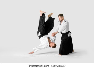 Two caucasian men are practicing aikido on the tatami (isolation path included)