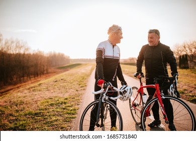 
Two Caucasian Middle-aged Cyclists Stand On The Road