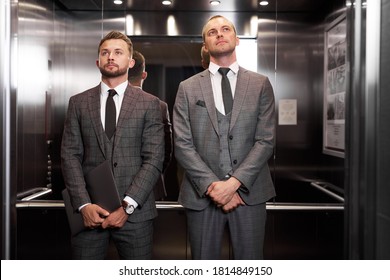 two caucasian serious businessmen met in the elevator, waiting to get out of there, each on their own business