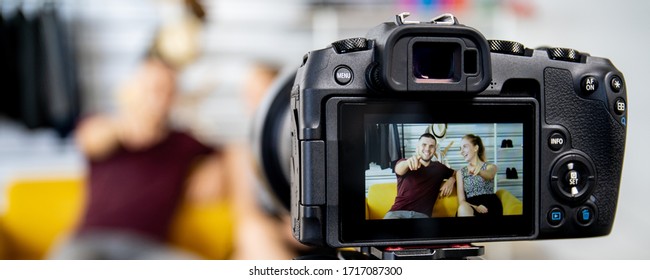 Two Caucasian Video Blogger (Vlog) Are Live Streaming Their Content And Sharing Through The Internet. Happy Couple Talking In Front Of The Camera And Sharing Their Video On The Social Network.