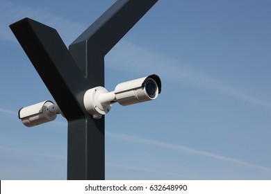 Two CCTV Security camera on clear sky background