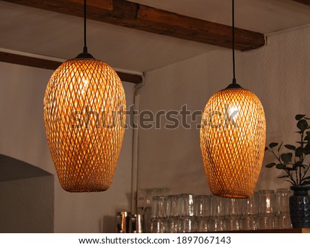 two ceiling lights made of brown rattan hanging from the ceiling