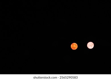 Two celestial bodies glowing in the night sky, showcasing a vibrant contrast.