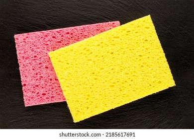 Two cellulose sponges on a slate stone, close-up, top view.