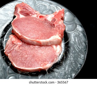 Two Center Cut Pork Chops On A Clear Plate