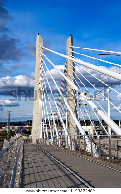 Two central support columns with rope stretching\
of pedestrian, bicycles and transportation Tilikum Crossing Bridge\
with railway for streetcar across the Willamette River in Portland\
Oregon