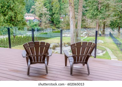 Two Chairs On Porch With A Foret River View.