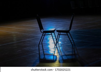 Two Chairs On The Stage With Blue Lights.