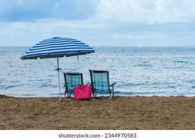 two chairs and one umbrella alone on the beach - Powered by Shutterstock